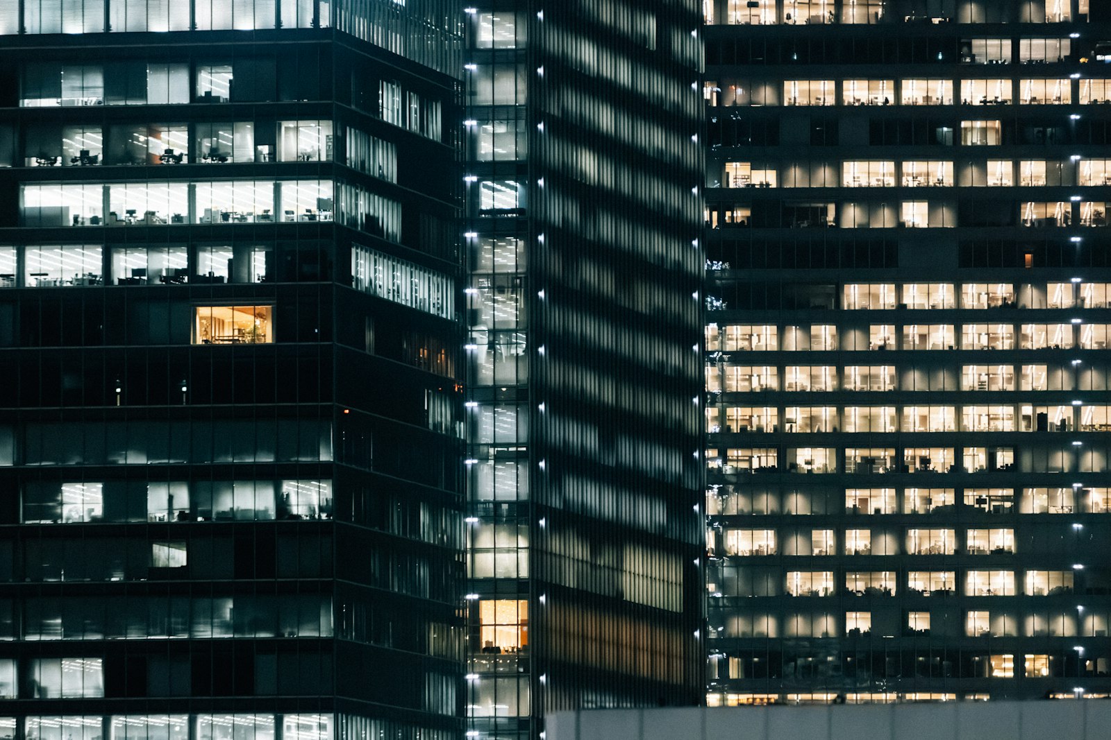 Night-lit commercial glass facades with cool interior light behind the panes